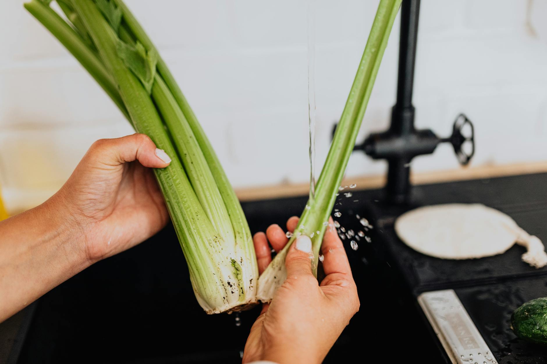 woman washing celery in kitchen